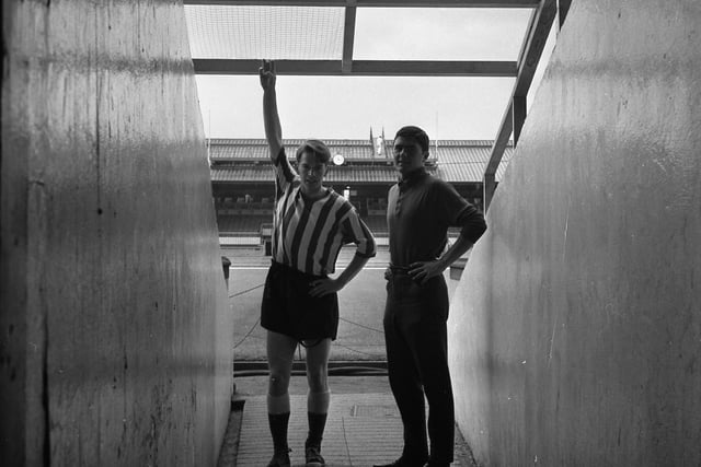 Sunderland players Colin Suggett, left, and Derek Forster, right, are pictured watching the latest preparation work at Roker Park - the erection of a wire mesh cover over the players' tunnel. Picture: Bill Hawkins.