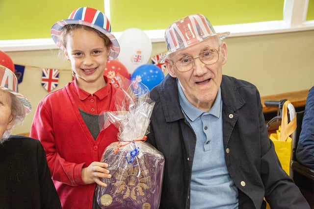 Plains Farm Academy pupil Maghnia Hartwell gives a present to the Village Care Home resident Alfred Wild.