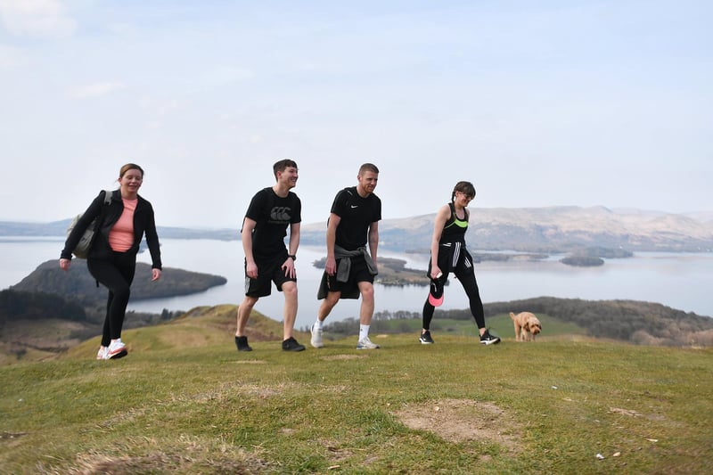 A group of people enjoying a walk on Conic Hill, overlooking Loch Lomond.