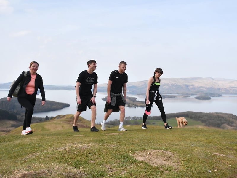 A group of people enjoying a walk on Conic Hill, overlooking Loch Lomond.