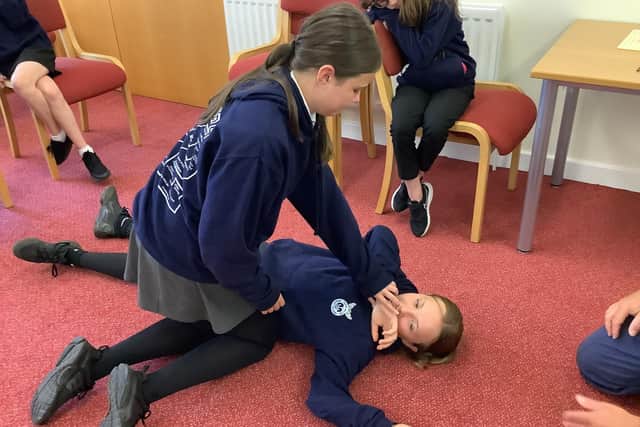 Pupils learn how to put a casualty into the recovery position.