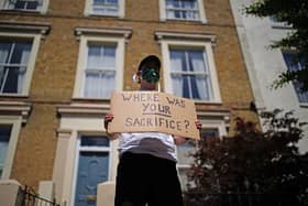 A protester holds a sign up outside the home of Prime Minister Boris Johnson's senior aide Dominic Cummings in north London. Picture: PA.