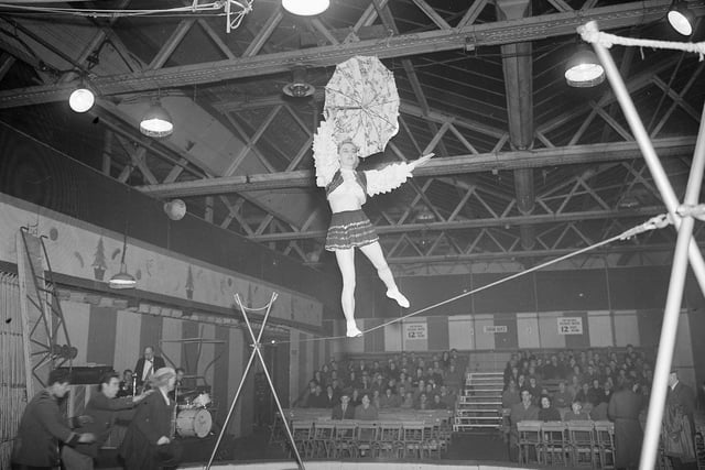 A tightrope walker balances above the ring at a circus in Waverley Market in January 1955.