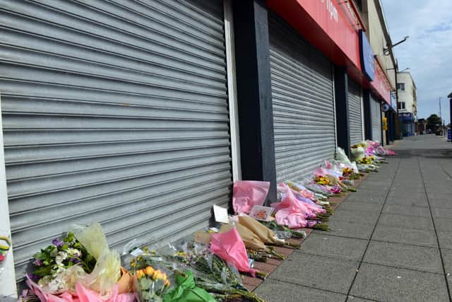 Flowers outside the One Stop Store after Joan Hoggett was killed