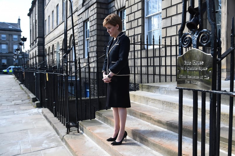 Scotland's First Minister Nicola Sturgeon observes a minute's silence outside Bute House in Edinburgh to mark the start of the funeral service of the Duke of Edinburgh.