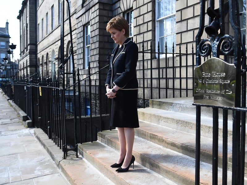Scotland's First Minister Nicola Sturgeon observes a minute's silence outside Bute House in Edinburgh to mark the start of the funeral service of the Duke of Edinburgh.