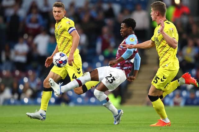 Nathan Tella of Burnley controls the ball under pressure from Charlie Cresswell and Shaun Hutchinson of Millwall. (Photo by Alex Livesey/Getty Images).