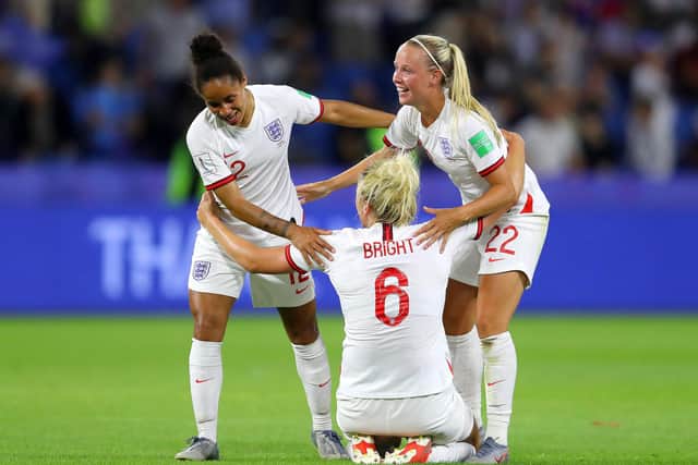 Millie Bright celebrates victory with Demi Stokes and Beth Mead after the 2019 World Cup quarter-final match between Norway and England.