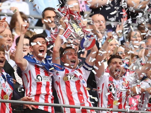 Corry Evans lifts the trophy as Sunderland secure promotion with a 2-0 win