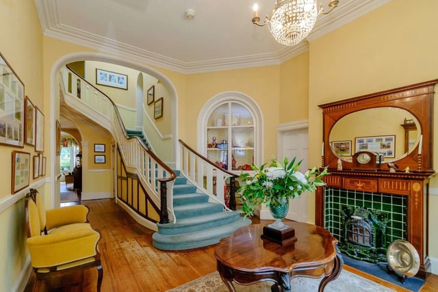 The house opens into a full length grand entrance hall, with a sweeping staircase set under a glazed lantern.