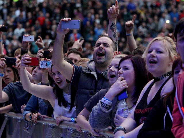 Spectators photograph their heroes.