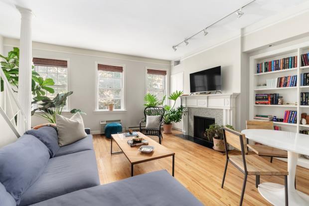 The second floor of the upper duplex has a living room, with wood-burning fireplace, bathed in natural sunlight through three west-facing windows.