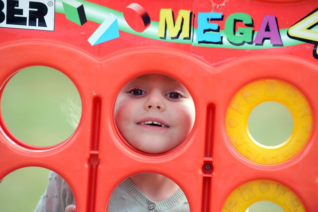 Sienna Hall, three, looking through the giant Connect 4 game.