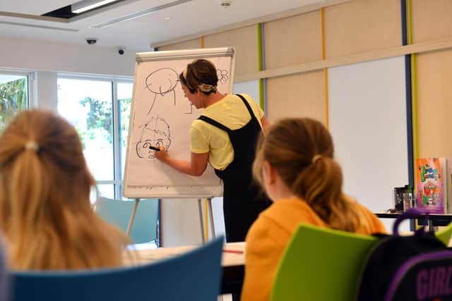 Author and illustrator Liz Million teaching children how to create animal character drawings.