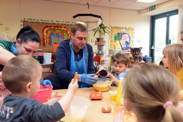 Children add eggs to their cake mix with a helping hand from reporter Neil Fatkin.