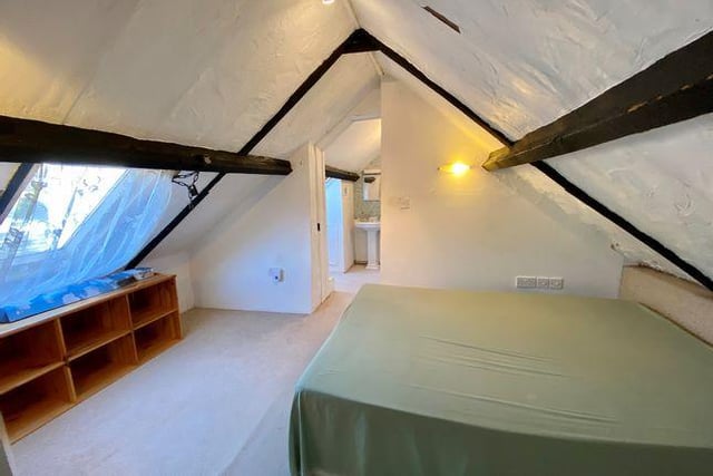 The main bedroom boasts a sloping ceiling and feature beams