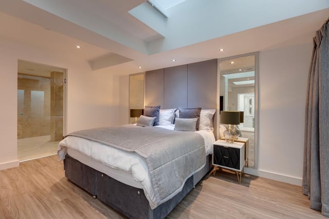 The master bedroom has obscured glazed roof lights, recessed lighting, built-in speakers, a fitted air conditioning unit and engineered timber flooring with under floor heating. Double UPVC doors with double glazed obscured panels open to a paved light well. The room is linked to a dressing room, and an en-suite bathroom.