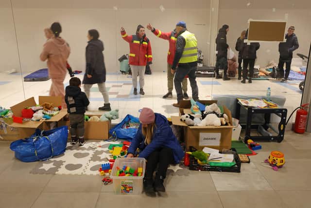 PRZEMYSL, POLAND - MARCH 03: A mother and child who have fled from war in Ukraine sit among donated toys at a temporary shelter set up in a former shopping center on March 03, 2022 in Przemysl, Poland. Most arrivees spend only a short time at the shelter before being picked up by relatives among the Ukrainian diaspora or traveling onward by bus or train. Over one million people have left Ukraine since Russian launched its military invasion one week ago. (Photo by Sean Gallup/Getty Images)