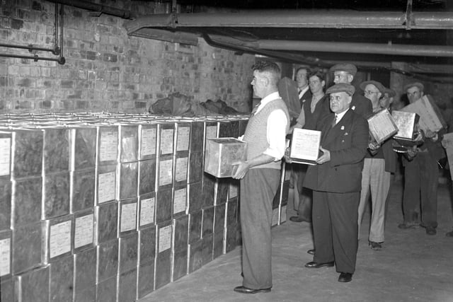 Staff with some of the 3,500 sealed tins containing gas masks which were stored in the basement of Monkwearmouth Hospital in 1938.