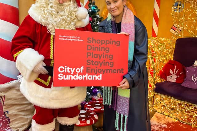 Santa handing over a giant Sunderland Gift Card to Amy Nunn from Sunderland BID