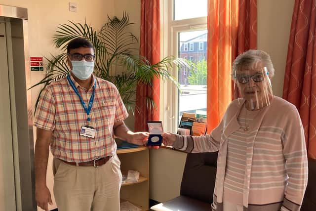 Margaret (right) being presented with her medal by Dr Shaz Wahid.
