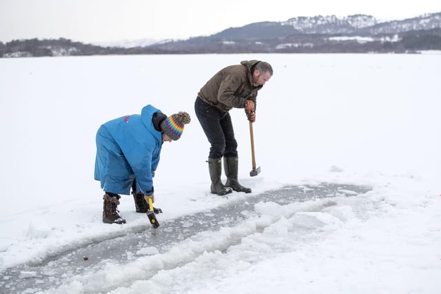 Al and Alice Goodridge, from Newtonmore, use a sledgehammer and an axe to create a channel in the ice in Loch Insh, in the Cairngorms National Park, for Alice to swim in.