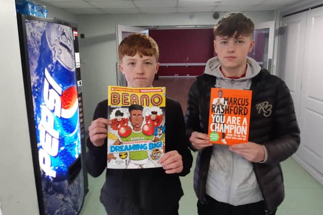 Shane and Warren Brewster with copies of Marcus Rashford's book and comic.