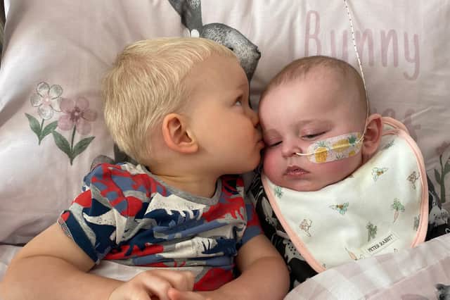 Big brother George with Nellie Hammond, who has been diagnosed with an extremely rare condition.