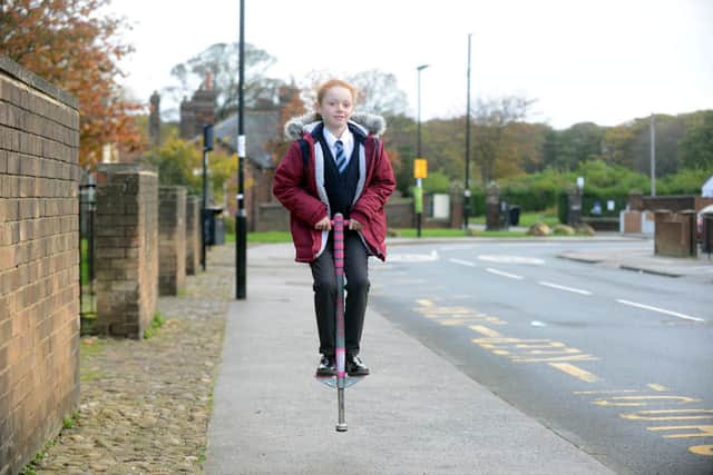 Isla Leigh-Bell, eight, using her pogo stick to get to school.