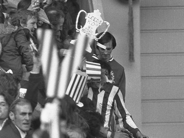 Fans try to get a glimpse of the Sunderland players, including Ian Porterfield and David Young, as they descend the Wembley steps at the end of the game.