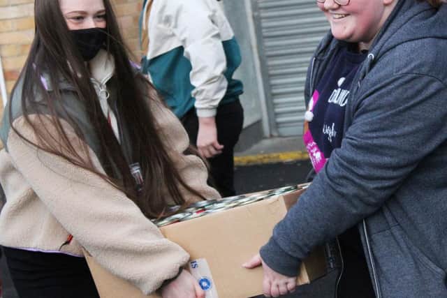 Students Madison Slee, 16, and Kirsty Young, 17, delivering some of the 3,000 tins.