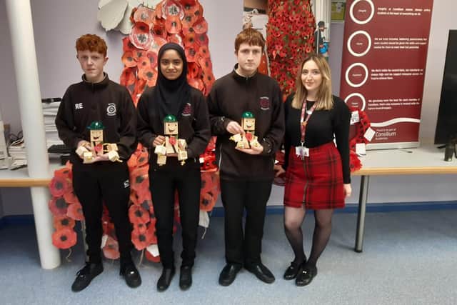Pupils Robert Edwards, 15, Thakylya Islam, 14 and Liam Robson, 14, with the wooden soldiers  they made, alongside teacher Siobhan Mills
