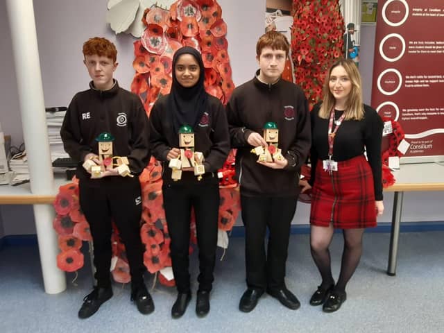 Pupils Robert Edwards, 15, Thakylya Islam, 14 and Liam Robson, 14, with the wooden soldiers  they made, alongside teacher Siobhan Mills