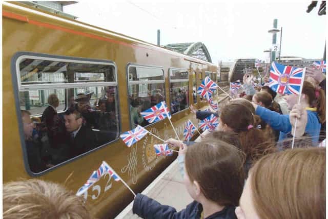 Children stood on platforms along the line to wave their flags as the Queen went by on the train.