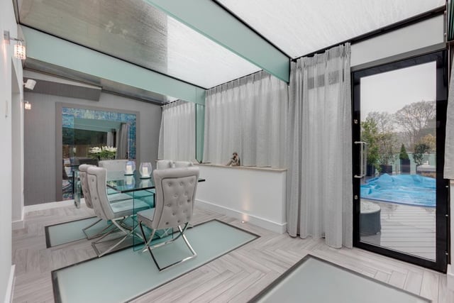 The sun room doubles as a dining room - it has a triple glazed roof, built-in speakers, tiled flooring with feature up-lighters, decorative obscured glass floor panels and underfloor heating. Double doors with double glazed panels open to the exterior of the property.