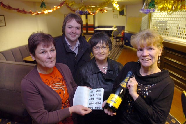This 2009 photo shows Christine Collins, left, and Linda Watts, right, handing cash raised at the Belle Vue Social Club to Greg Hildreth and Janice Forbes from Alice House Hospice.