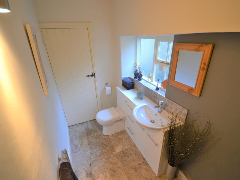 Incorporating a wash basin inset to a gloss-white vanity unit with matching low-flush WC.