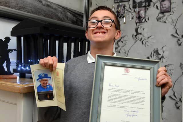 Hugh Clinton, 13, holding his letter and card addressed from the Queen.