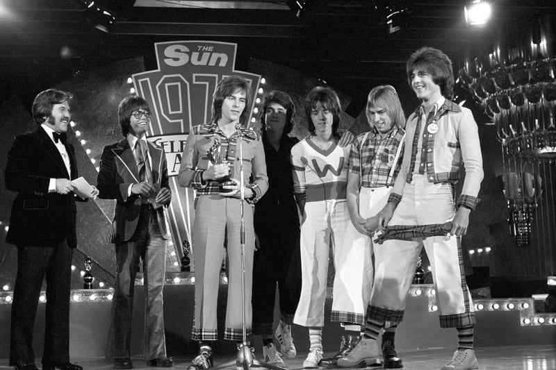 The Bay City Rollers with the award for the Top Pop Act presented to them by pop star Cliff Richard, second left, at the 1975 Sun Television Awards ceremony at the London Hilton Hotel.
