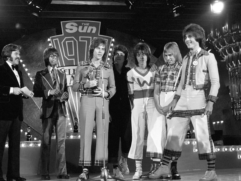 The Bay City Rollers with the award for the Top Pop Act presented to them by pop star Cliff Richard, second left, at the 1975 Sun Television Awards ceremony at the London Hilton Hotel.