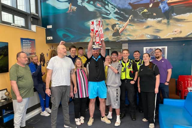 Swan Lodge staff and residents lift the trophy