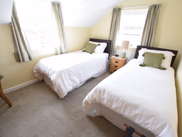 The guest house's twin room is described as a "pleasant and sunny room situated at the rear of the property".