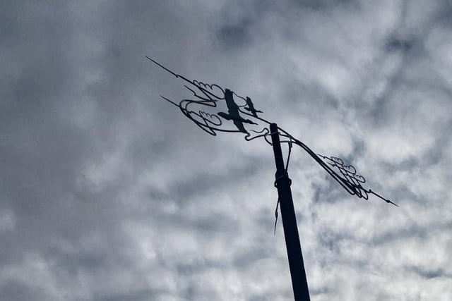 Walk your way around the Marina, look up, and you'll find Flight. Created by Craig Knowles, a forged steel weathervane set on a painted steel pole rises from a concrete base. 
Two cormorants in a polished silver finish are shown flying through stylised clouds and the vane rotates above a north-south pointer. Cormorants are regularly seen flying low over the river.