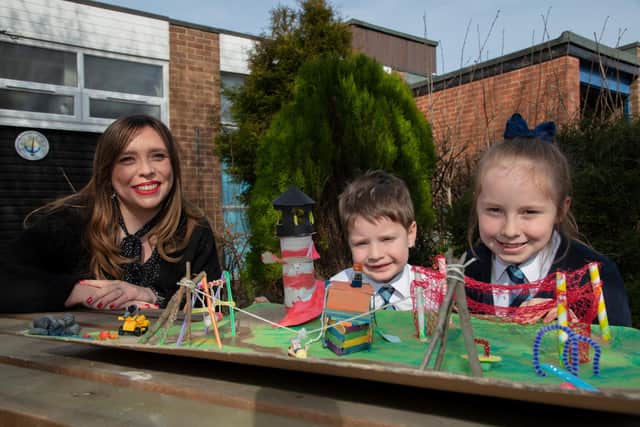 Councillor Rebecca Atkinson with competition winners Sophia and Henry Nixon and their 3D design of the new play park.