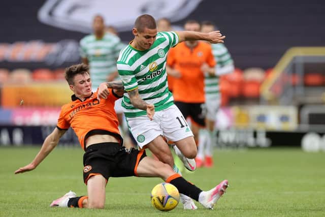 Patryk Klimala of Celtic is tackled by Jamie Robson of Dundee United.