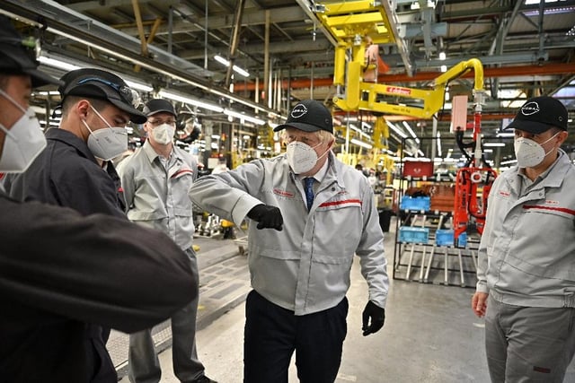 Mr Johnson elbow bumps some staff at the Nissan plant. Photo: Jeff J Mitchell/Getty Images.
