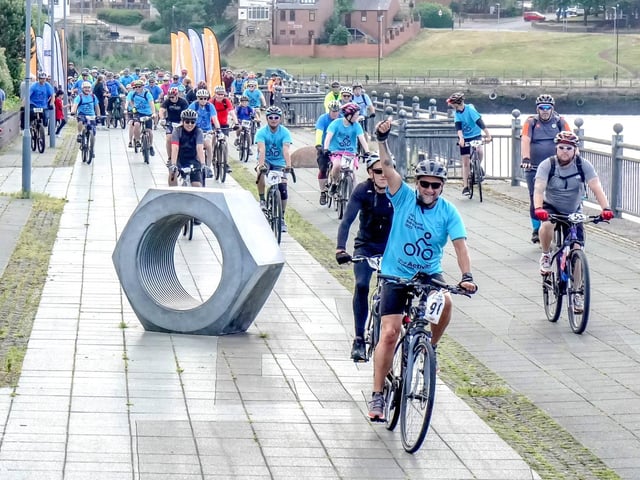A cyclist raises his arm.