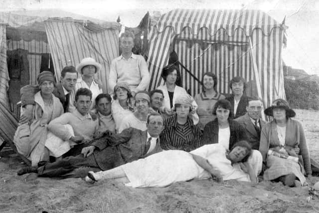 Sara Butterfield with her family and friends on the beach with their tents in the 1920s.