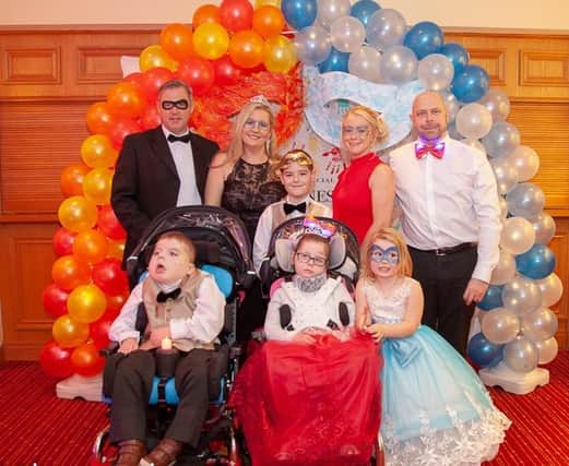 Claire Stewart and Amy Howes, founders of the Special Lioness charity with their families at a Special Lioness masquerade ball