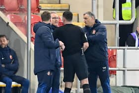 Referee Matt Taylor talks to the Sunderland management team during the game against Rotherham United.